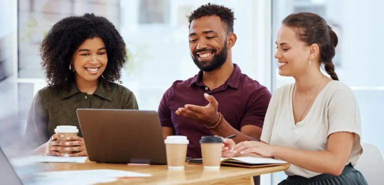 A group of adult students looking at a laptop screen