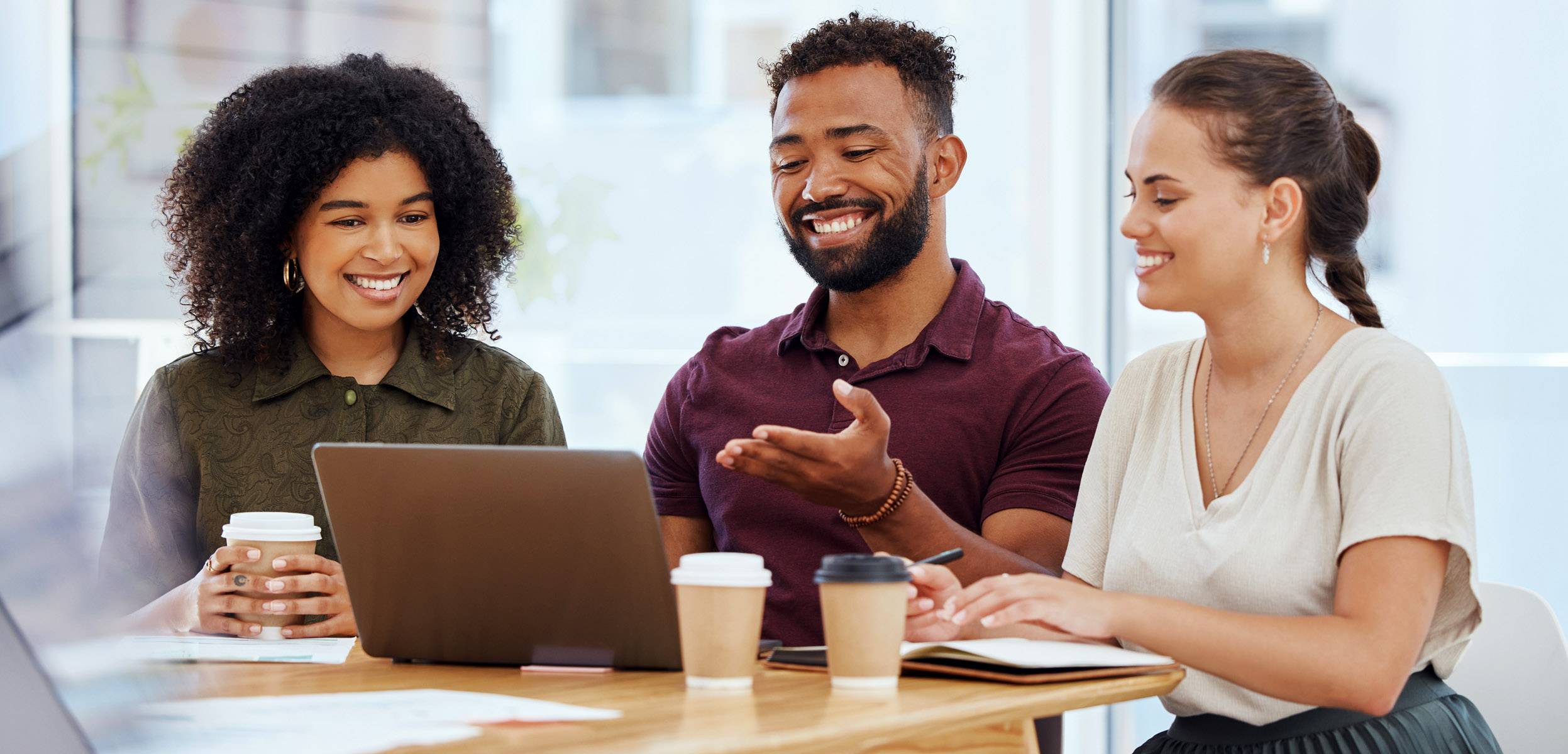 A group of adult students looking at a laptop screen